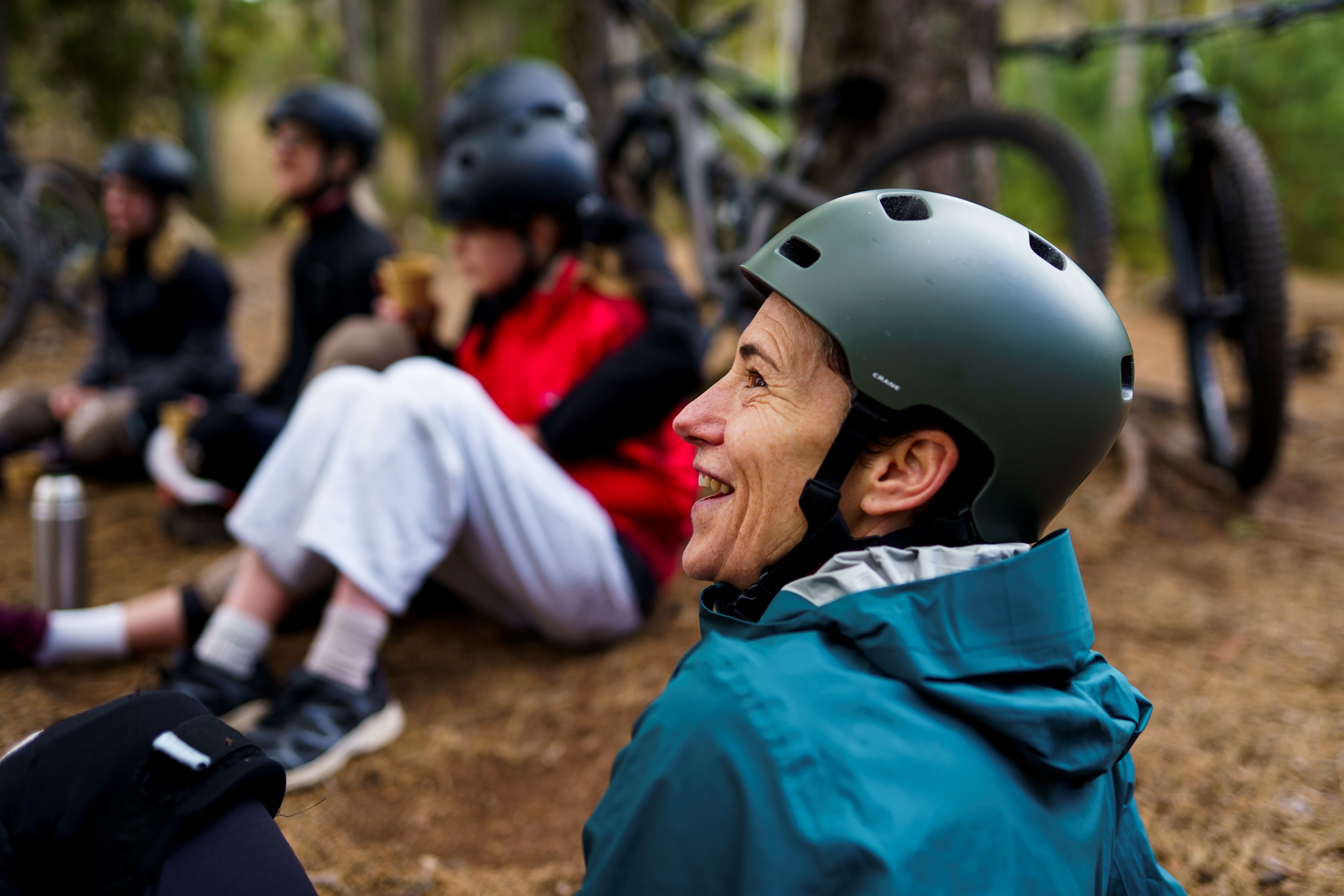 Bild på människor sittandes i skogen emd cykelhjälm